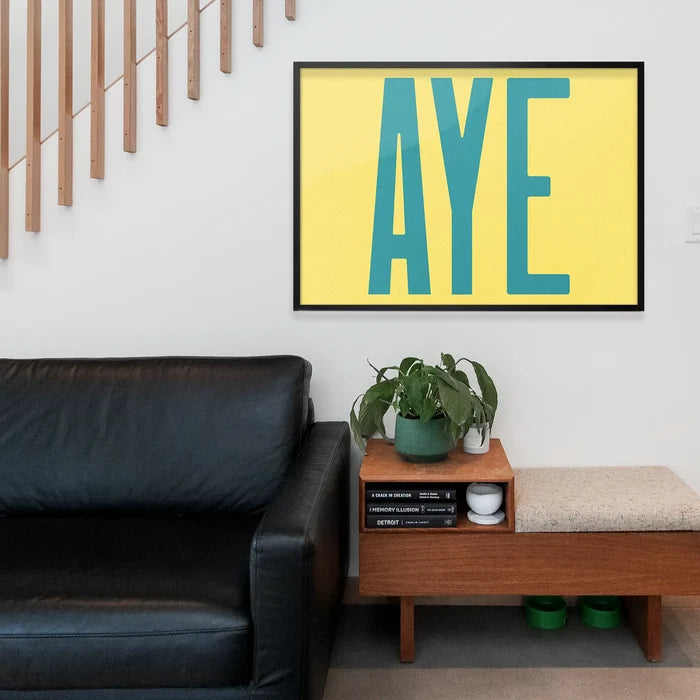 Aye Typography Quote Print - Duck Egg Blue framed above a living room sofa