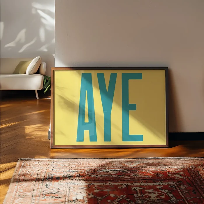 Aye Typography Quote Print - Duck Egg Blue framed, leaning on a wooden floor beside a rug