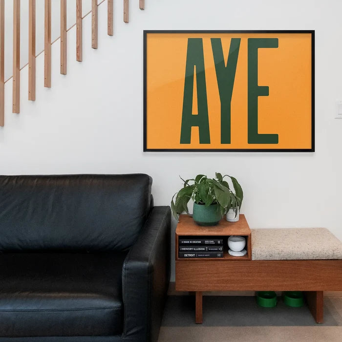 Aye Typography Quote Print - Forest Green framed above a living room sofa