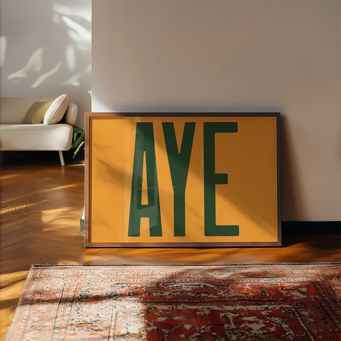 Aye Typography Quote Print - Forest Green framed, leaning on a wooden floor beside a rug