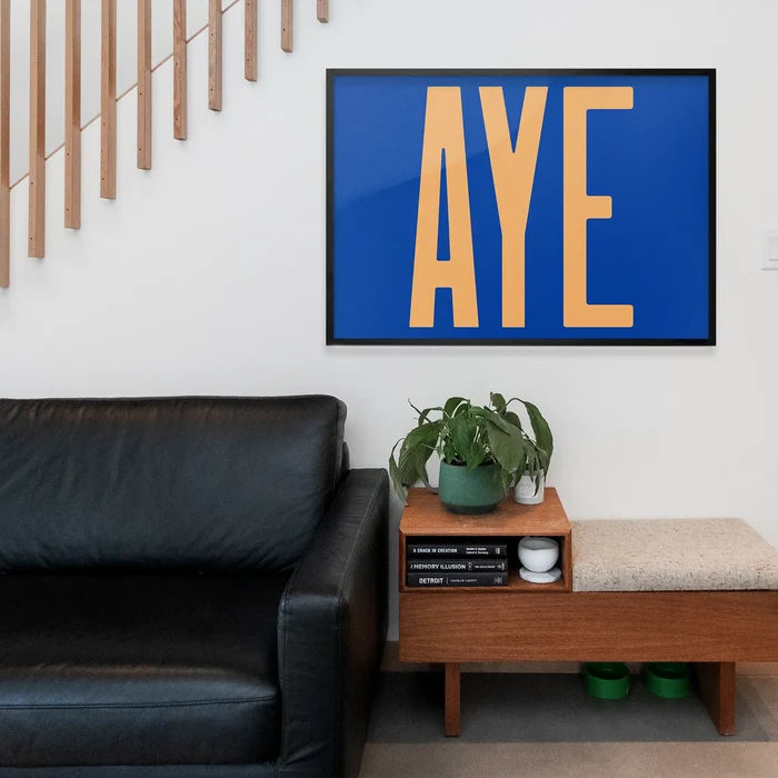 Aye Typography Quote Print - Peach framed above a living room sofa