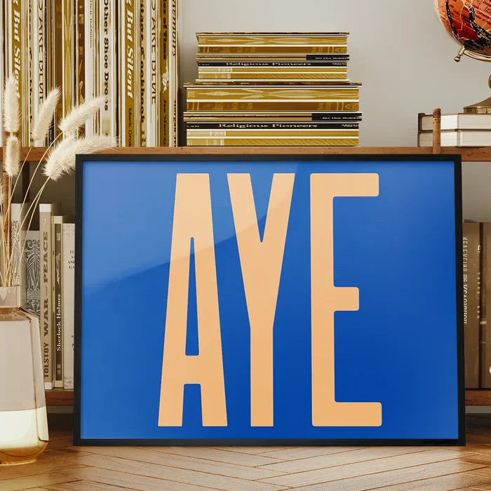 Aye Typography Quote Print - Peach framed on a living room bookshelf