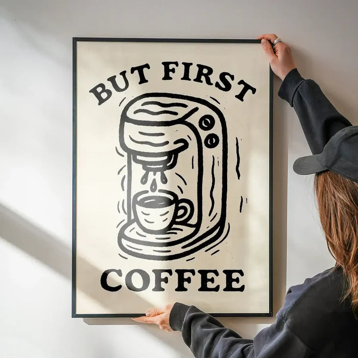 But First Coffee Quote Print being hung on a wall in a black frame
