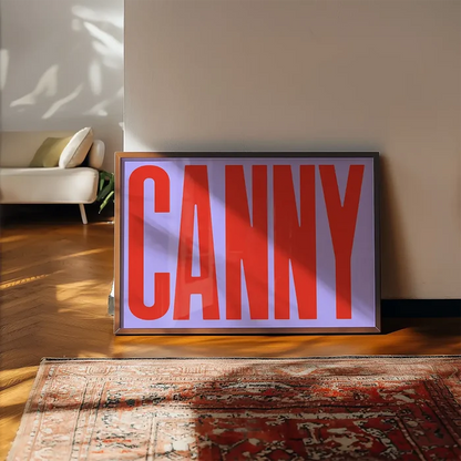 Canny Typography Quote Print - Red framed, leaning on a wooden floor beside a rug