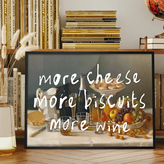 More Cheese Biscuits Wine Quote Print framed on a living room bookshelf