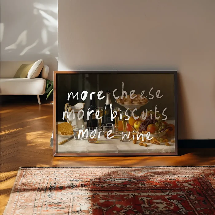 More Cheese Biscuits Wine Quote Print framed, leaning on a wooden floor beside a rug