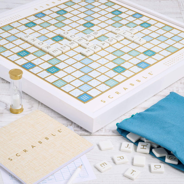 Scrabble game set with board, tiles, and dictionary on a wooden surface